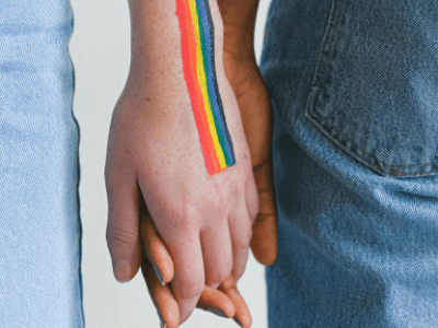 people holding hands with pride colour paint